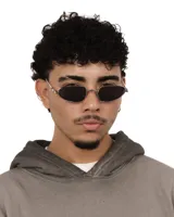 Lentes de sol con marco plateado y cristales oscuros, de forma ovalada y estilo retro. Ofrecen protección UV400 y son polarizados.