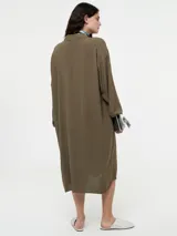 Vestido camisero negro de lino con botones delanteros y bolsillos ocultos.