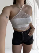 Top blanco de encaje con tirantes finos y espalda descubierta.
