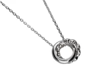 Collar de plata con cadena de eslabones y dije de dos círculos entrelazados, uno liso y otro con pequeños corazones de circonia.