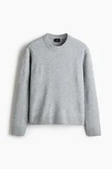 Buzo de punto gris melange con acabado cepillado, cuello redondo, mangas largas y puños y bajo acanalados.