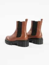Botas Chelsea de cuero color marrón con elástico lateral negro y suela track negra.