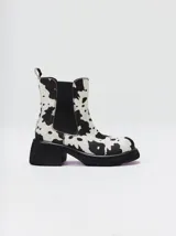 Bota tipo chelsea de cuero vacuno en color rojo con estampado floral grabado en negro. Presenta paneles laterales elásticos, suela de plataforma y taco cuadrado en color negro.