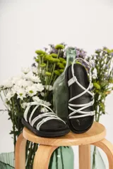 Sandalias negras con tiras plateadas y hebilla al tobillo.