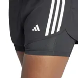 Shorts deportivos Adidas Own The Run 2 en 1, color negro, con tres franjas blancas verticales en los laterales. Presenta un short exterior de corte regular y un short interior ceñido. La cintura elástica lleva la inscripción "RUNNING".