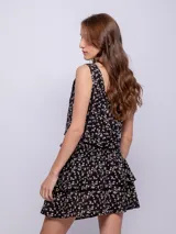 Minifalda negra con estampado de pequeñas flores, diseño de capas con volados y cintura elástica fruncida.