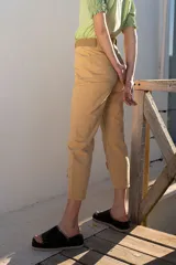 Pantalón de jean color beige, de tiro alto, corte recto y largo a media pierna con ajuste en el bajo.