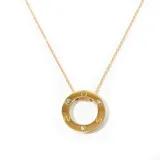 Collar dorado con dije circular con incrustaciones de strass y grabados.