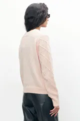 Sweater rosa pastel de tejido de punto con estructura en forma de rombos y apliques de perlas.