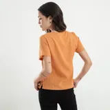 Blusa verde de manga corta con escote en V profundo y textura acanalada o plisada verticalmente. Corte holgado.