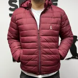 Campera puffer de nylon color bordó con capucha y cierre frontal.