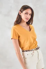 Remera de algodón color mostaza, de manga corta y escote en V con detalle metalizado.