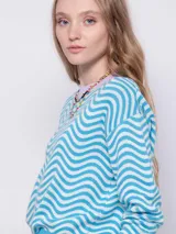 Sweater de punto con diseño jaquard de ondas en color rosa y blanco, con cuello redondo en color verde lima, de manga larga y corte holgado.