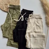 Pantalón verde militar de corte recto con cintura elástica ajustable con cordón.