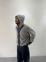 Campera reversible con cierre frontal. Un lado confeccionado en algodón azul marino con estampa plastisol, bordados con apliques y capucha. El otro lado presenta un diseño de polar de pelo largo en color gris. Posee corte oversize, puños y ruedo acanalados.