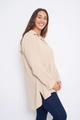 Camisa color beige de poliéster de seda, manga larga, con cuello camisero y corte recto.