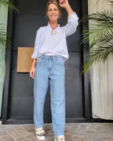 Pantalón de jean estilo mom fit en color azul claro, con tiro medio, cierre frontal con botón y bolsillos laterales.