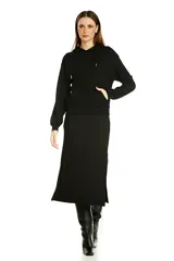 Conjunto de dos piezas en color negro, compuesto por un buzo con capucha y bolsillo frontal tipo canguro, y una falda midi de corte recto con tajo lateral.