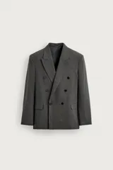 Blazer gris de corte relaxed fit con diseño de raya diplomática, cuello con solapas de pico, doble botonadura cruzada y bolsillos con solapa en la cadera.