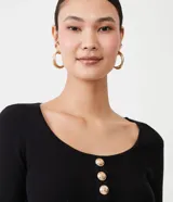 Blusa negra de punto con escote en U, mangas largas y detalle de tres botones dorados.