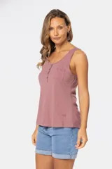 Musculosa blanca sin mangas, de corte clásico y calce cómodo, confeccionada en tejido suave. Presenta escote redondo, cartera con botones frontales y un pequeño bolsillo aplicado en el pecho.