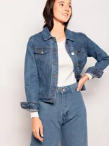 Campera de jean clásica con lavado vintage, corte corto, bolsillos frontales y cierre mediante botones metálicos.