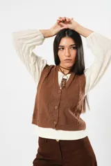 Blusa color manteca de cuello redondo y mangas largas abullonadas con puños elásticos.