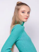 Polera de punto a rayas verticales en tonos gris plata y negro, de cuello alto y manga larga.