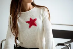Sweater de punto color crema con una estrella roja en el centro.