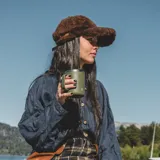 Gorro con visera marrón de corderito sintético.