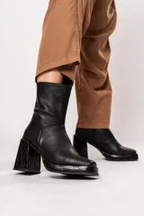 Bota de caña media color negro, de cuero, con horma cuadrada, taco geométrico con textura símil cocodrilo y plataforma.