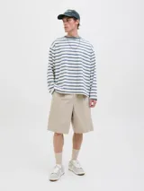 Short color beige de tiro medio con cierre de cremallera, bolsillos delanteros y traseros.