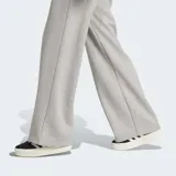 Pantalón Adidas de pernera ancha, color gris melange, confeccionado en suave tejido de felpa francesa. Cuenta con cintura elástica y el logo del trébol bordado en la parte superior delantera.