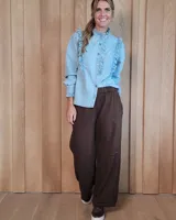 Pantalón de algodón color arena, de corte recto y holgado, con cintura elástica y detalle de costuras horizontales decorativas en la parte inferior de las piernas.