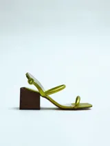 Sandalia de mujer color verde lima metalizado con tiras finas y taco ancho de madera oscura. Posee tira ajustable en el talón.