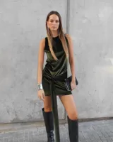 Vestido corto de terciopelo verde militar, con cuello halter, corte ajustado y detalle de nudo lateral con caída.