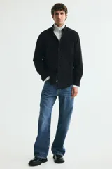 Camisa Oxford de algodón color negro, con cuello abotonado, cierre frontal con botones blancos y un bolsillo en el pecho.