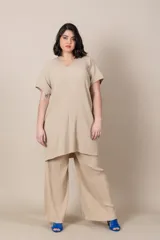 Blusa italiana larga color beige, con escote en V, mangas cortas y diseño plisado.