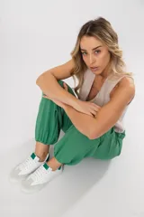 Zapatillas acordonadas de cuero color blanco con puntera de gamuza gris y detalles en verde.