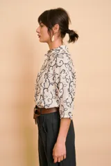 Camisa blanca de manga larga con cuello mao y estampado de motivos vegetales en tono azul oscuro.