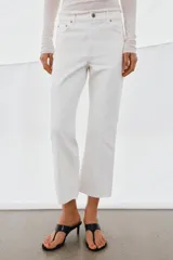 Jeans de tiro medio con corte flare y largo cropped. Presentan diseño de cinco bolsillos, cierre frontal con cremallera y botón, raya planchada en el delantero y bajo desflecado con acabado evasé.