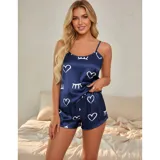 Conjunto de pijama de dos piezas compuesto por una musculosa de tirantes finos y un short, confeccionado en satén con acabado brillante. Presenta un estampado de corazones y figuras abstractas en color blanco sobre una base azul marino.