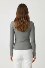 Remera de manga larga color blanco hueso, de tejido acanalado y corte ajustado al cuerpo, con cuello redondo.