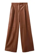 Pantalón de corte ancho y tiro alto, confeccionado en poliéster con recubrimiento de poliuretano de acabado símil cuero en color marrón, con pinzas en la cintura y bolsillos laterales.