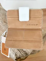 Billetera de cuero color blanco con estampado de cocodrilo dorado y cierre con broche.