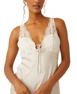 Vestido largo color crema con breteles finos regulables, escote en V y corpiño de encaje blanco con lazo en el centro.