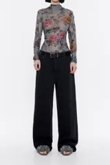 Pantalón vaquero negro de corte wide leg, tiro alto, cierre frontal con botón denim y cinco bolsillos.
