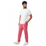 Pantalón de jogging rosado con puños elásticos y logo bordado en azul.