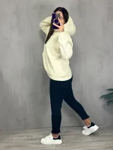 Canguro deportivo color crema con capucha y bolsillo tipo canguro.