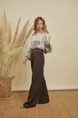 Pantalón sastrero de corte recto y tiro alto, confeccionado en tela con caída fluida, con bolsillos laterales y cierre frontal.